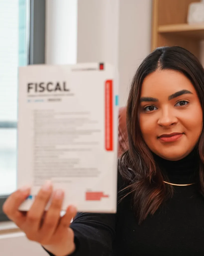 Dra. Thamyres Farias de Santana a consultar legislação fiscal, no escritório do Porto